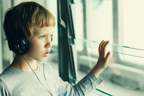 Child with autism spectrum disorder using headphones to block external stimuli