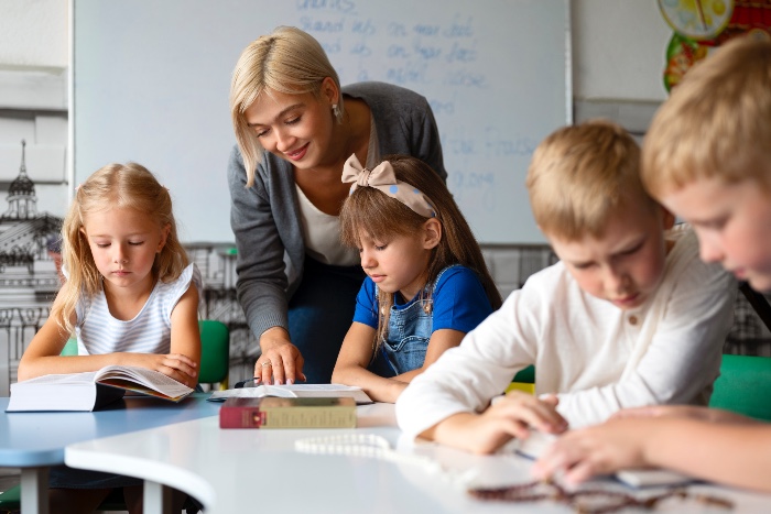 happy teacher and happy pupils in the classroom 