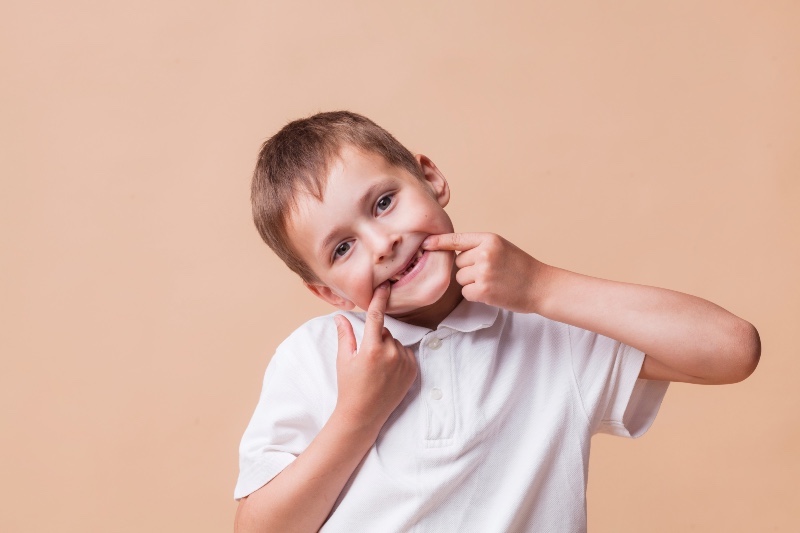 Child pulling faces to attract attention and a reaction.  A common form of attention seeking behaviour.