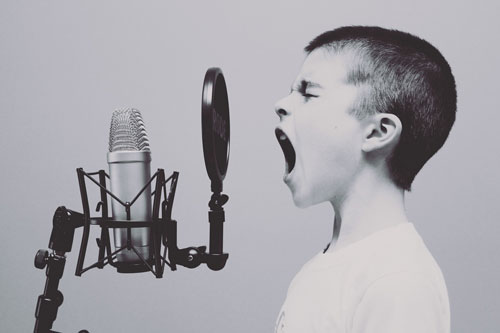 Attention seeking child shouting into a microphone