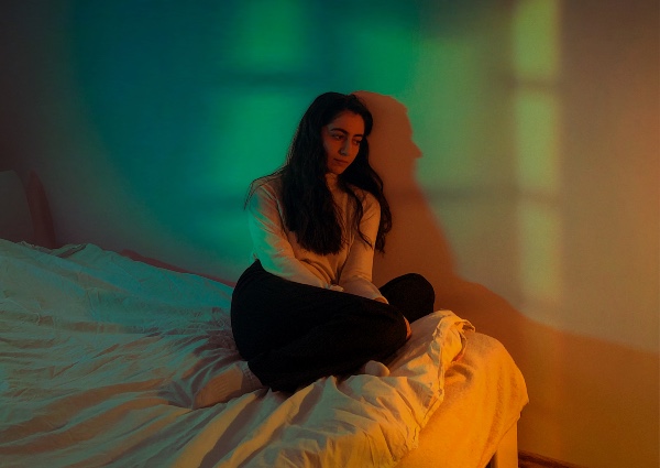 young female adolescent sitting in a dark room