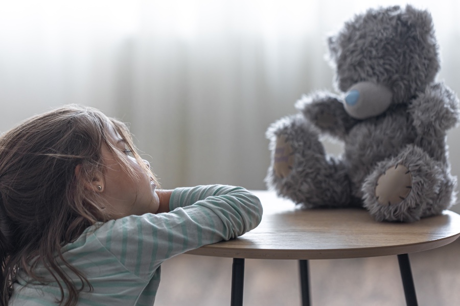 child showing no emotional attachment to teddy bear