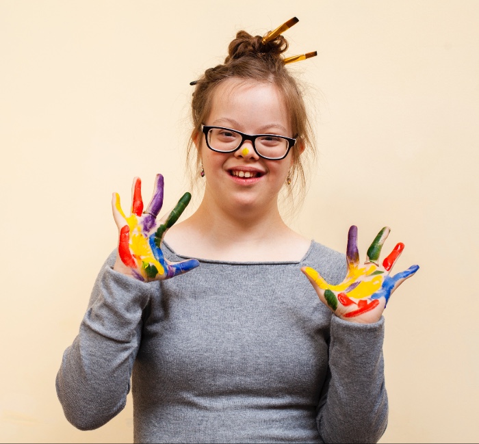 celebrating neurodiversity, a young woman with Down syndrome has painted her hands in bright colours
