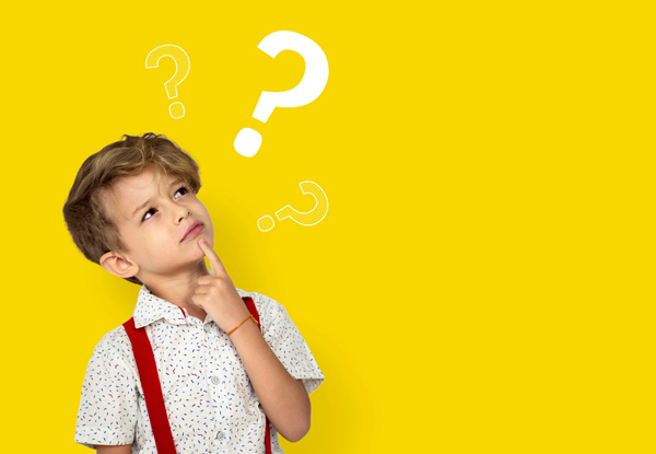 little boy having a think about theory of mind depicted by question marks floating above his head