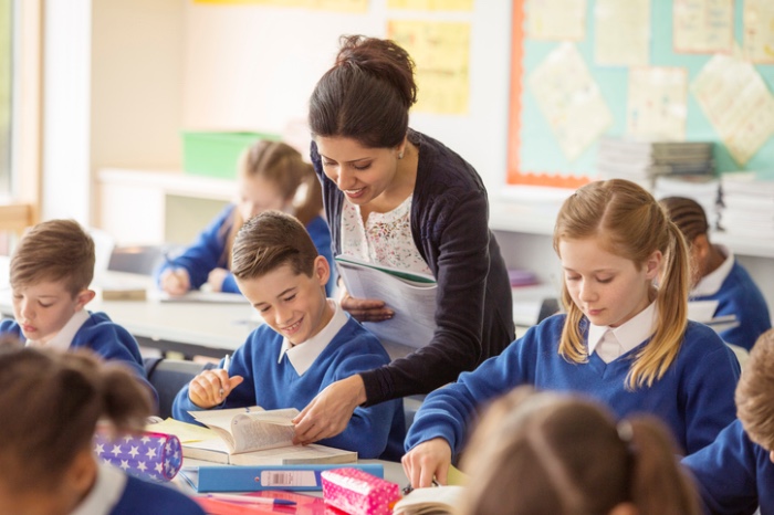 teacher assisting pupils in a UK school